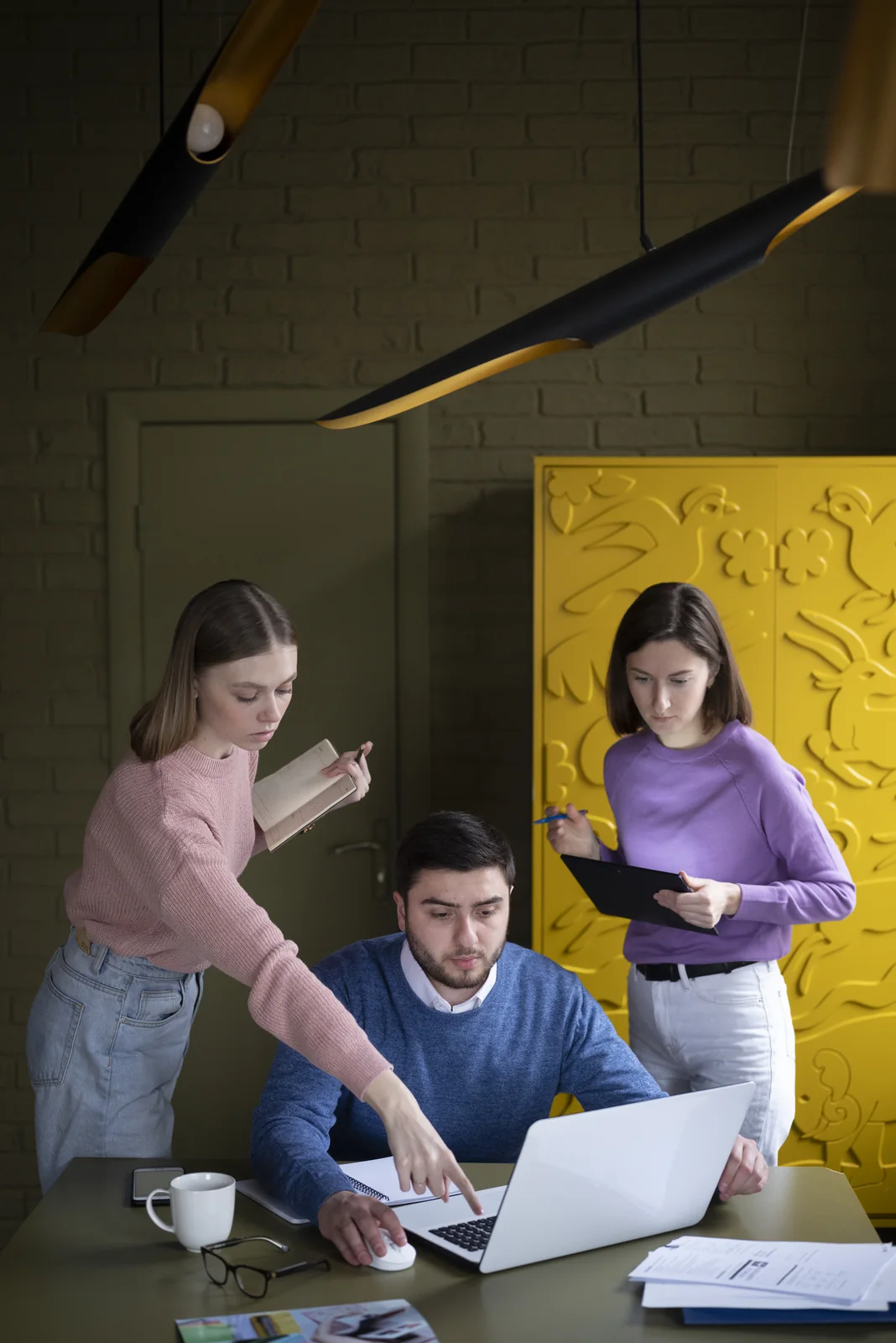 Team collaborating around a laptop in a modern workplace